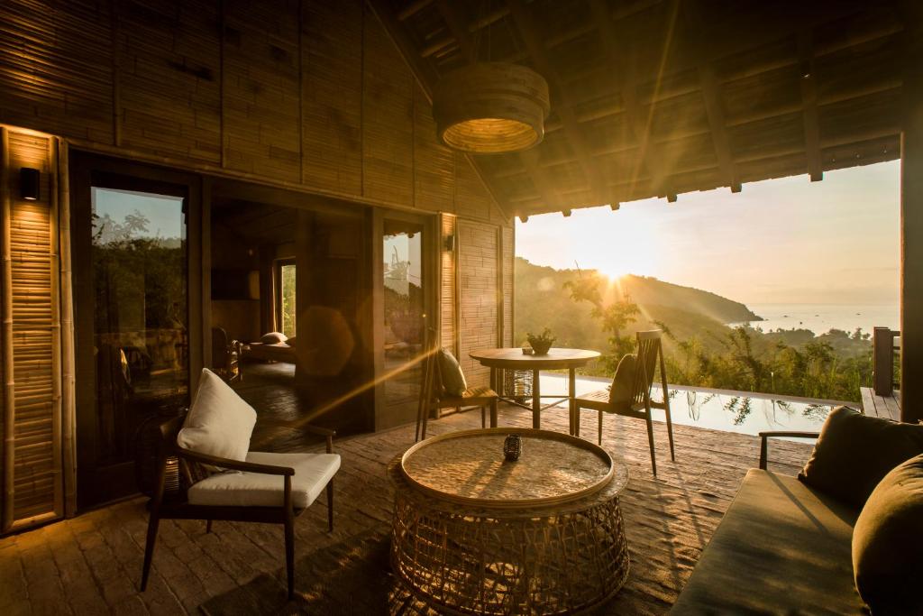 uma sala de estar com mesa e cadeiras e vista em Zannier Hotels Bai San Hô em Song Cau