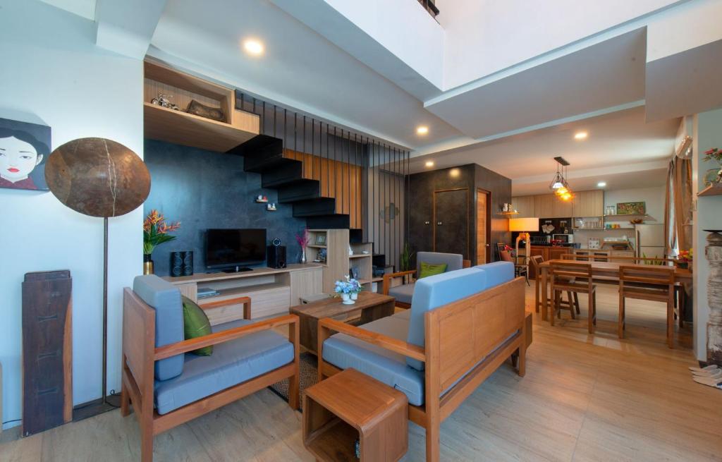 ein Wohnzimmer mit einer Treppe und ein Esszimmer in der Unterkunft Areya Villa in Chiang Mai