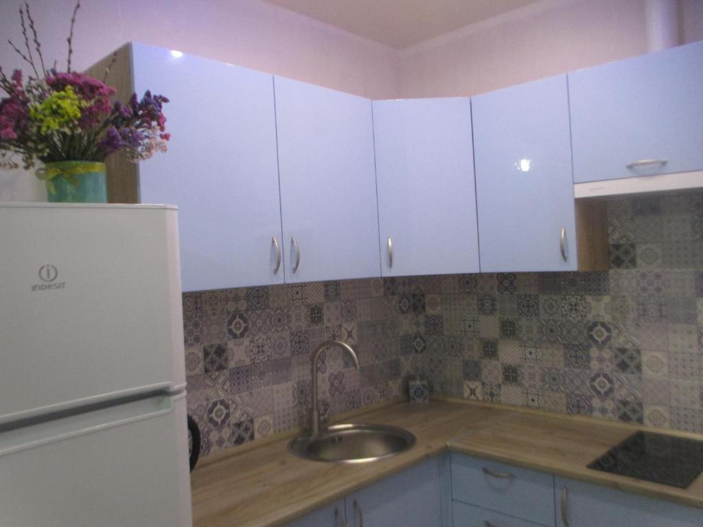 een keuken met witte kasten en een wastafel bij проспект Правды 41-е in Kiev
