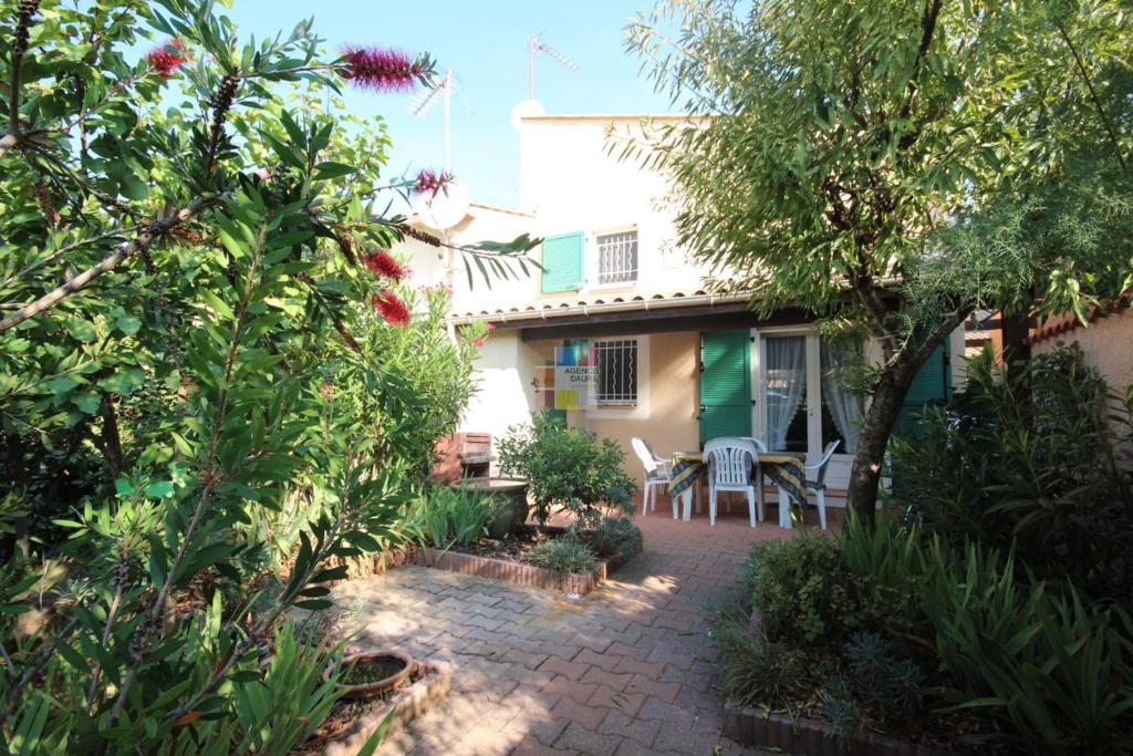 une maison avec un jardin et une terrasse dans l'établissement Belle villa plein sud, 4-6 couchages, en résidence avec piscine commune, Wifi fibre optique, 400m de la mer à PORTIRAGNES PLAGE LROND5, à Portiragnes