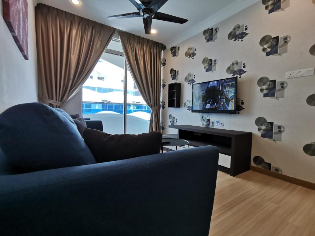 een woonkamer met een blauwe bank en een tv bij Thermospace The Wave B-13A-13 Melaka City in Melaka