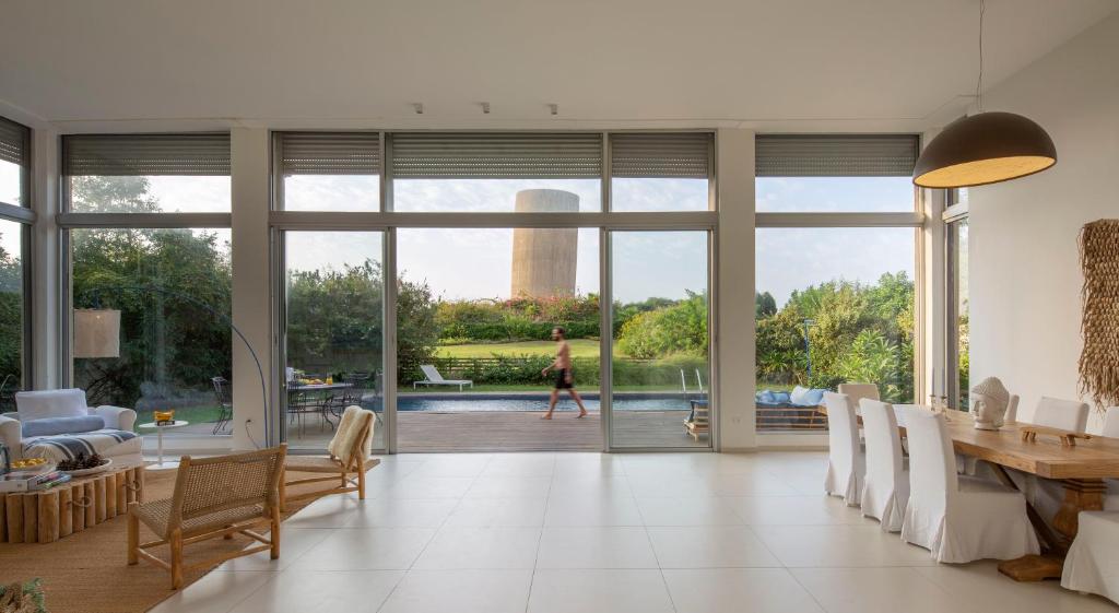 a living room with a table and a view of a pool at Beach House Galei in Herzliya B