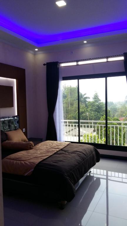 a bedroom with a bed and a large window at VILLA MB in Bogor