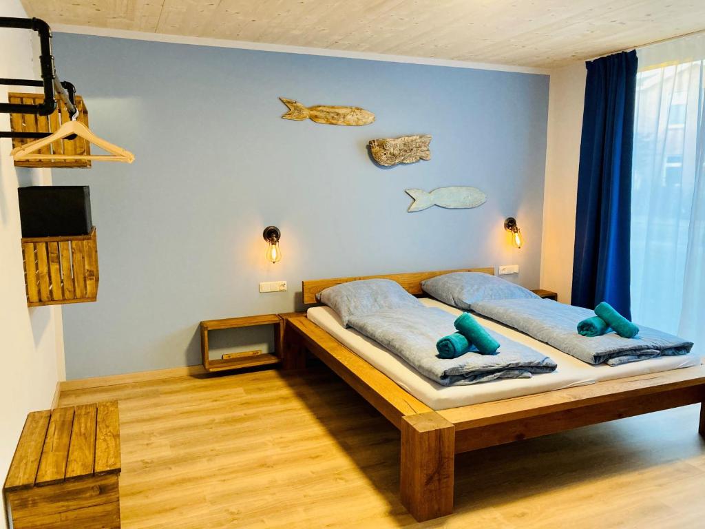 ein Schlafzimmer mit einem Bett mit zwei blauen Kissen in der Unterkunft Ankerix & Deichfix in Büsum