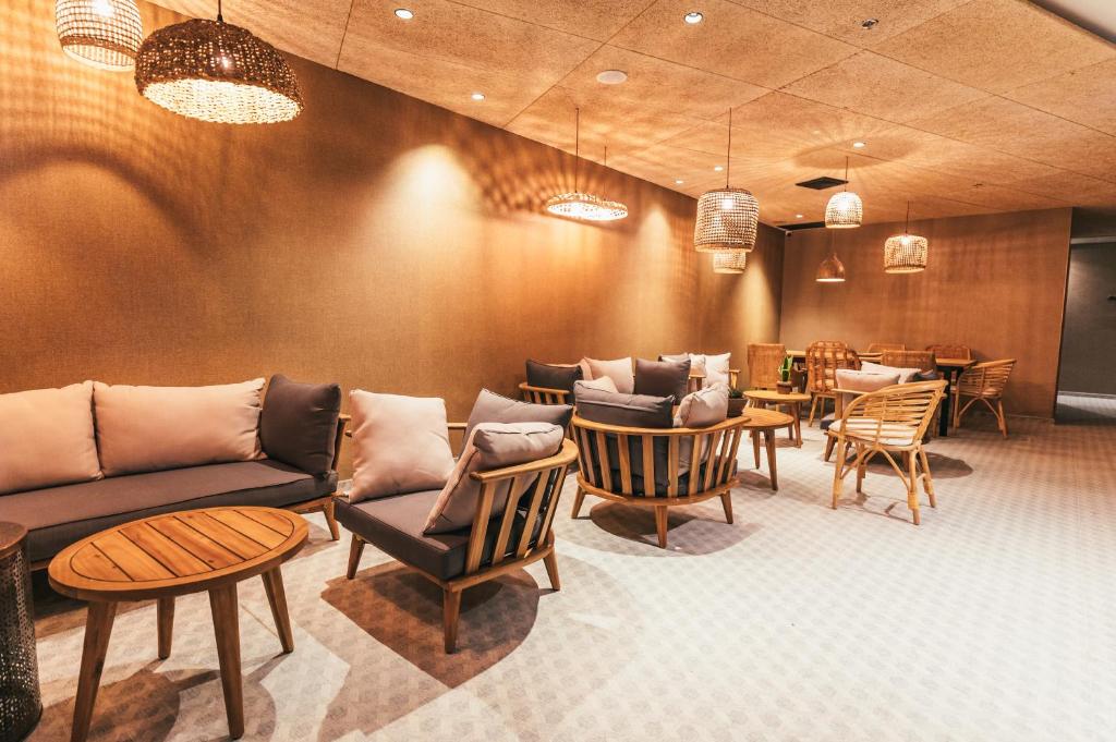 a restaurant with couches and tables and chairs at Even Derech by Smart Hotels in Mitzpe Ramon