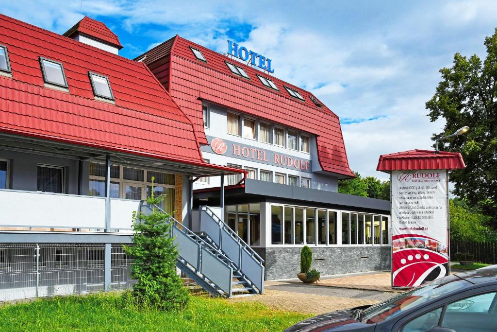 un edificio con techo rojo y una habitación de hotel en Hotel Rudolf, en Havířov