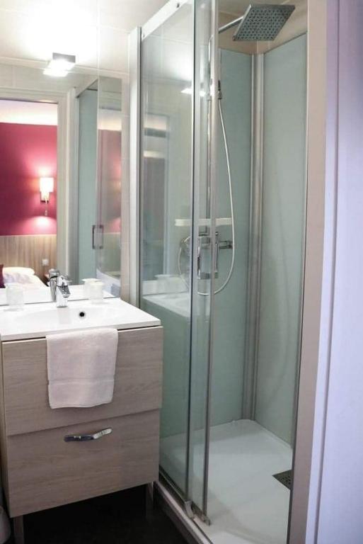 a bathroom with a shower and a sink and a toilet at HOTEL DU COMMERCE in La Châtre
