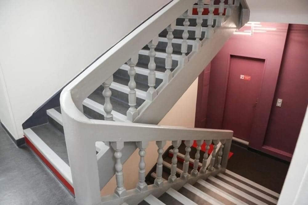 a staircase in a building with a red door at HOTEL DU COMMERCE in La Châtre
