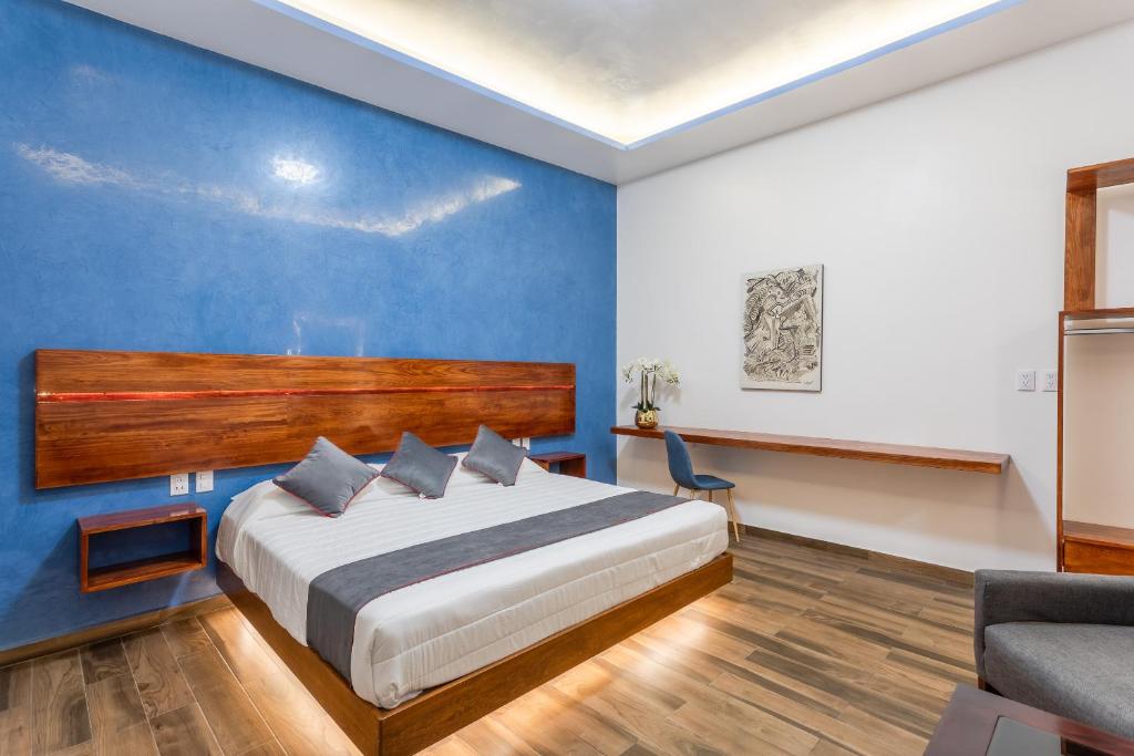 a bedroom with a bed and a blue wall at Casa Dos Lunas in Oaxaca City