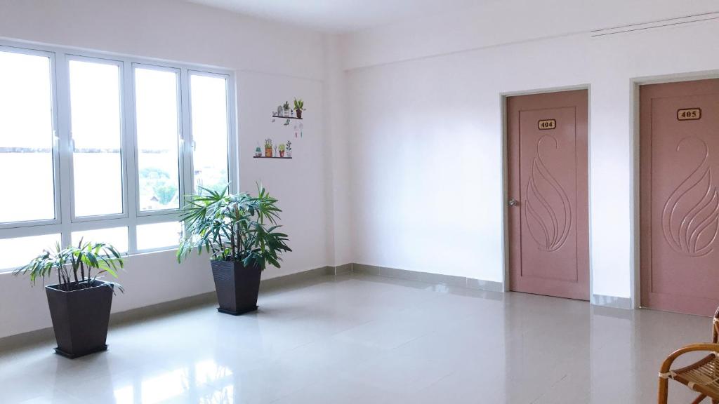 a room with two potted plants and a pink door at Alexis KT Roomstay in Kuala Terengganu