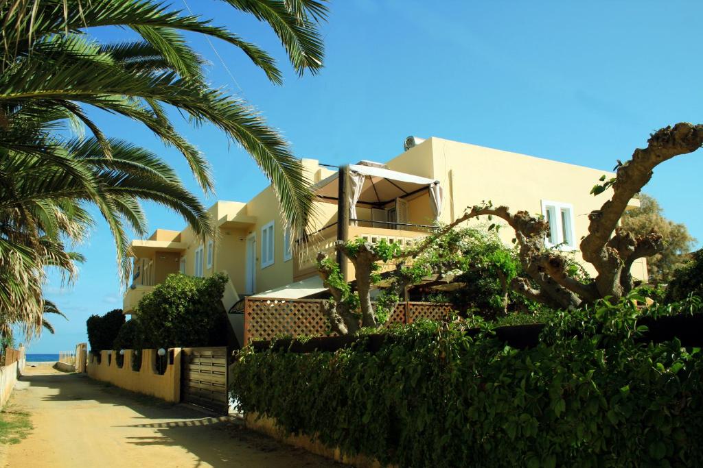 ゲラニ・シャニオンにあるAriana Studios and Apartmentsのヤシの木が植えられた浜辺の家