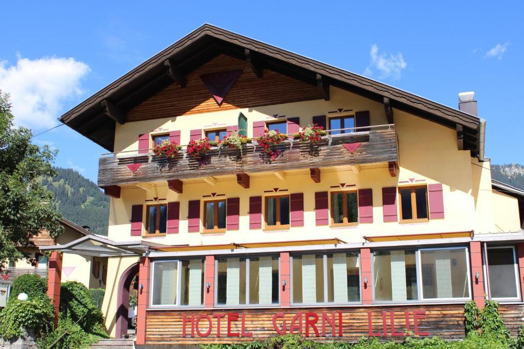 a building with a balcony with flowers on it at Die Lilie / Hotel Garni in Reutte