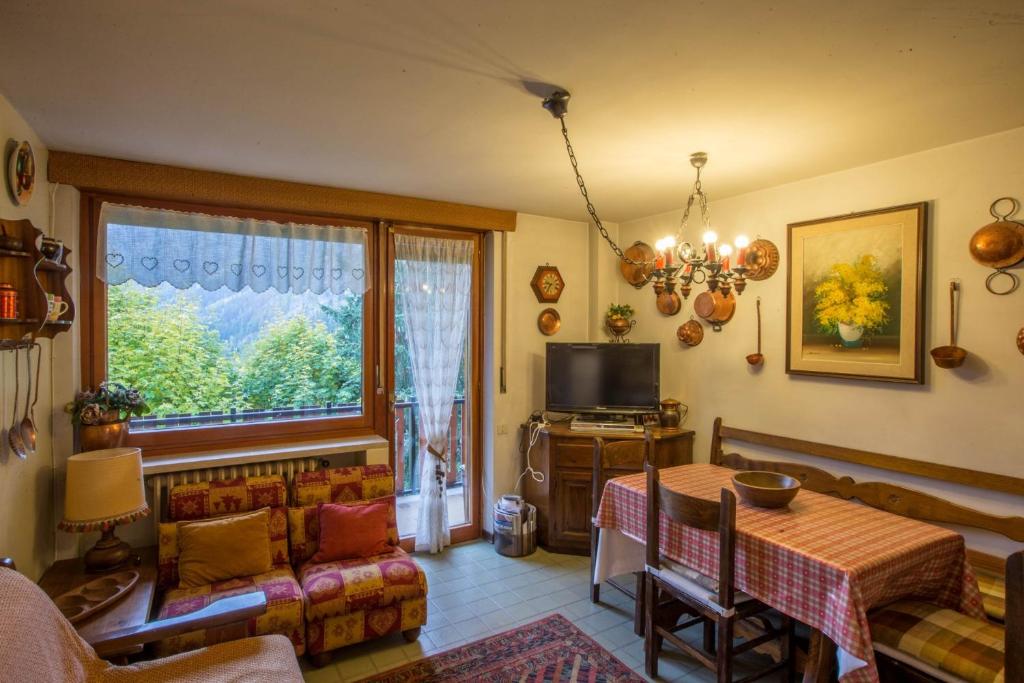 a living room with a table and a tv at ALTIDO Apt for 7 with Terrace and Exceptional Location in Courmayeur