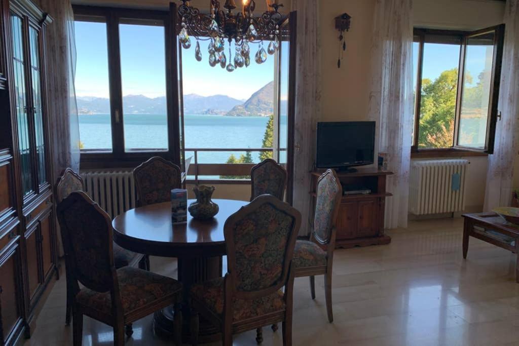una sala da pranzo con tavolo e sedie e vista di Oleandro a Stresa