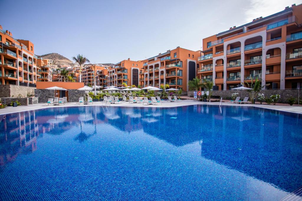 ein großer Pool vor einigen Gebäuden in der Unterkunft Arguineguín Park By Servatur in La Playa de Arguineguín