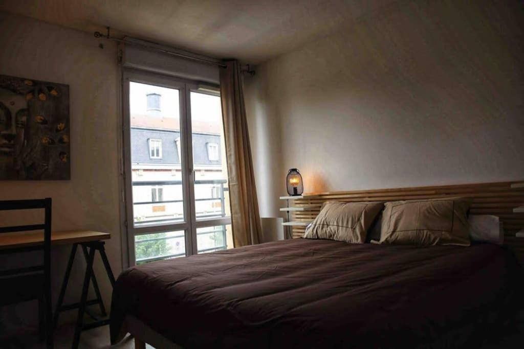 a bedroom with a large bed and a window at Appartement 55m2 centre ville Orléans in Orléans