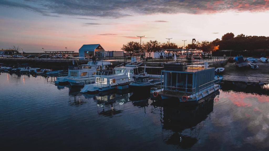 a group of boats docked in a marina at sunset at Barco Casa Marina Fuzeta in Fuzeta
