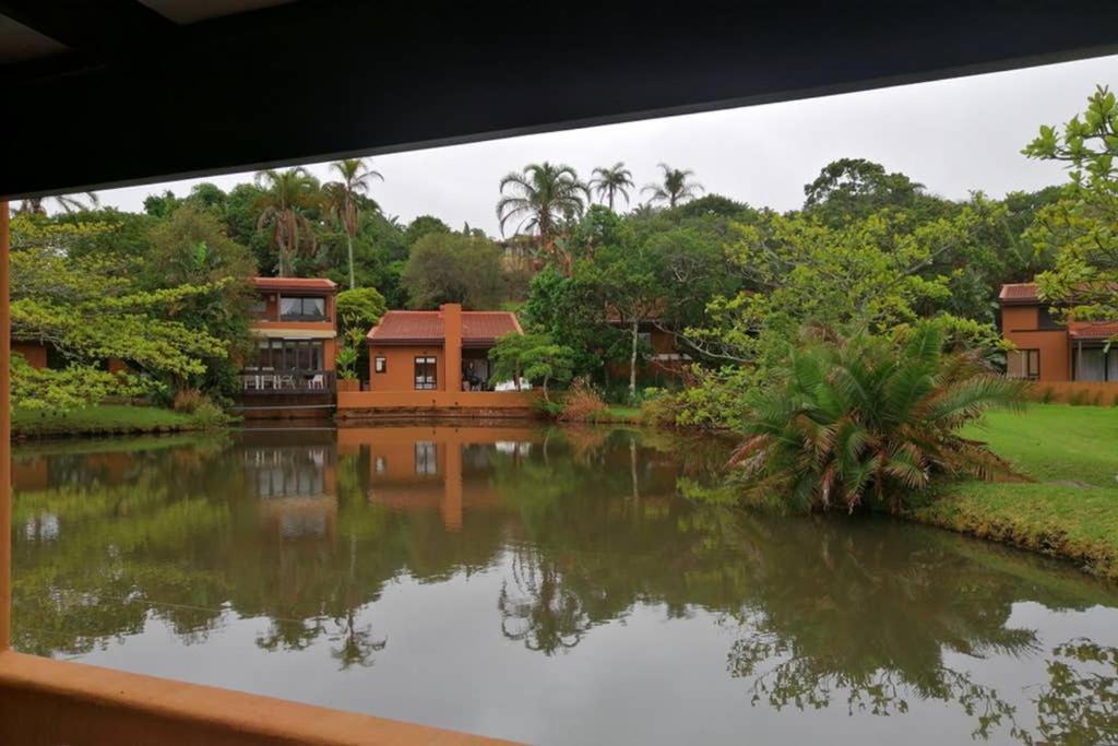 a view from a window of a house with a pond at San Lameer Villa 2026 in Southbroom