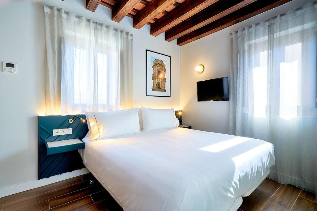 Tandem Torres de Cádiz Suitesにあるベッド