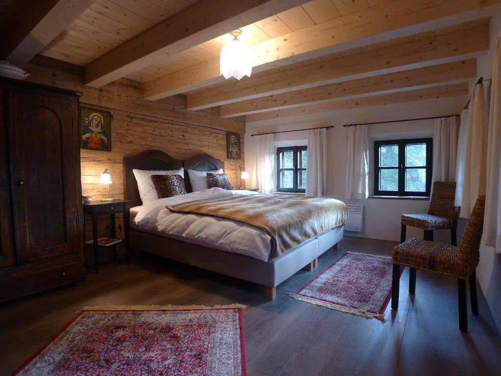 een slaapkamer met een bed en twee tapijten bij Heuholzmühle Privatzimmer in Elixhausen