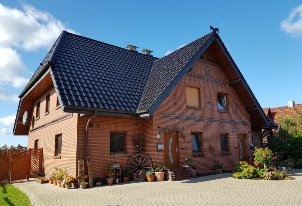 une grande maison en briques avec un toit noir dans l'établissement Ferienhaus Taucherperle, à Hemmoor