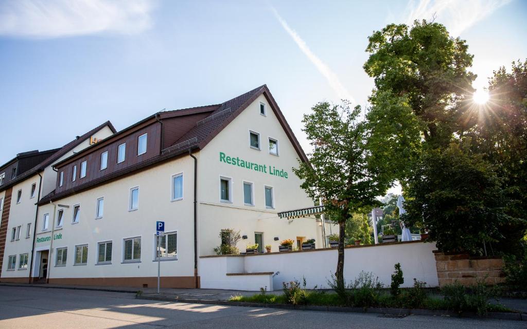 een wit gebouw met een bruin dak bij Hotel-Linde-Restaurant Monika Bosch und Martin Bosch GbR in Heidenheim an der Brenz