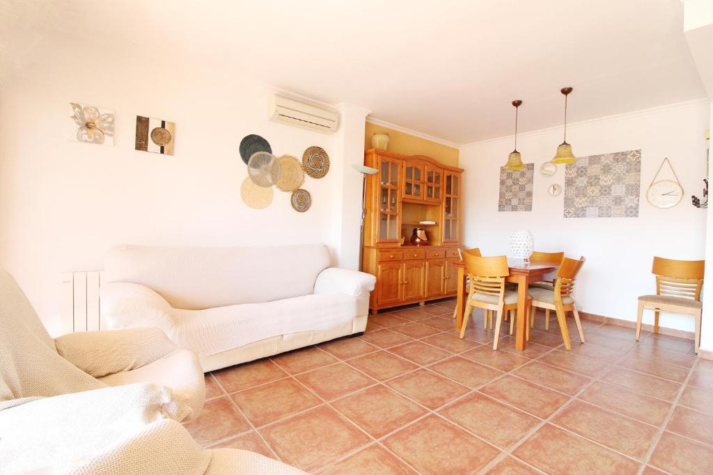 un soggiorno con divano bianco e tavolo di Global Properties, Ático con vistas en la playa de Canet a Canet de Berenguer