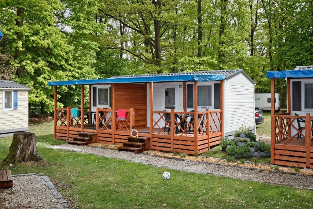 een tiny house met een blauw dak op een erf bij KNAUS Campingpark Essen in Essen
