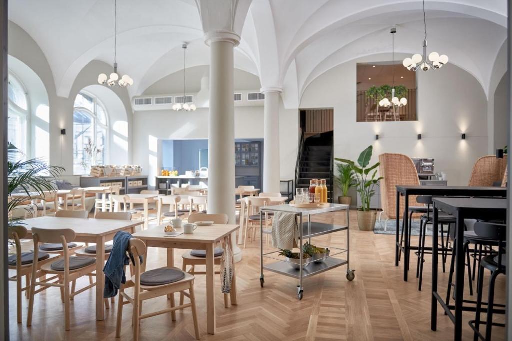 a restaurant with tables and chairs in a room at Moment Hotels in Malmö