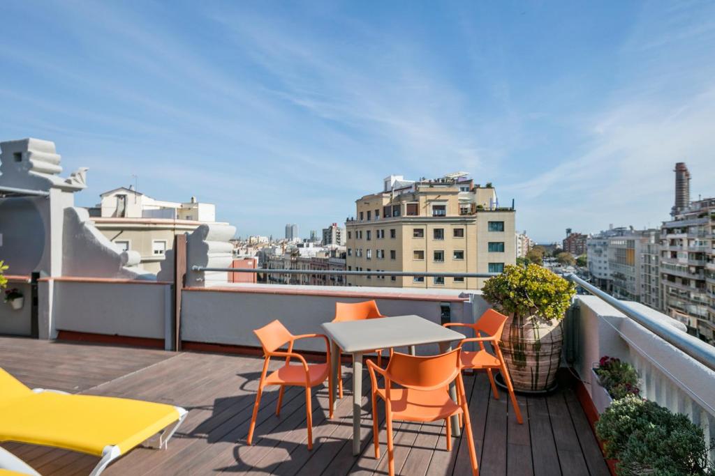 einen Balkon mit einem Tisch und Stühlen auf dem Dach in der Unterkunft Stay Together Barcelona Apartments in Barcelona