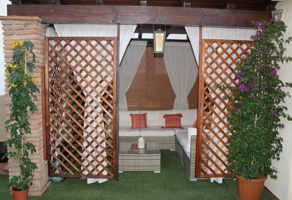 a gazebo with a bed and two plants at Ático Chill Out la Biznaga in Málaga