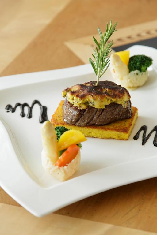 a plate of food with a piece of meat and vegetables at Hotel Plattenhof in Lech am Arlberg