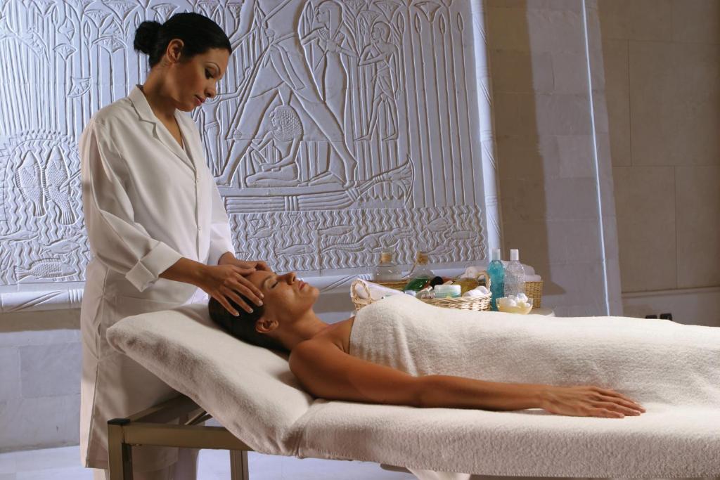 a woman giving a man a massage in a bath room at Intercontinental Cairo Citystars by IHG in Cairo