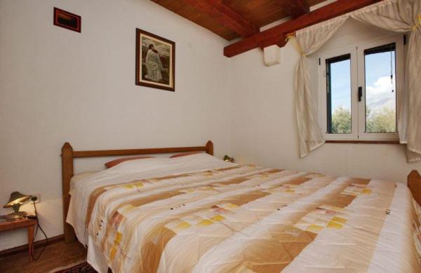 a bedroom with a large bed and a window at Apartman Zora in Drasnice