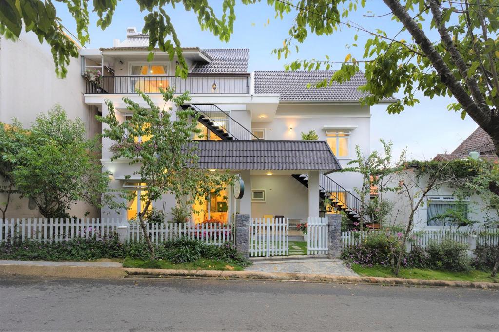 a white house with a white fence in front of it at Đỗ Gia Bảo Villa in Da Lat