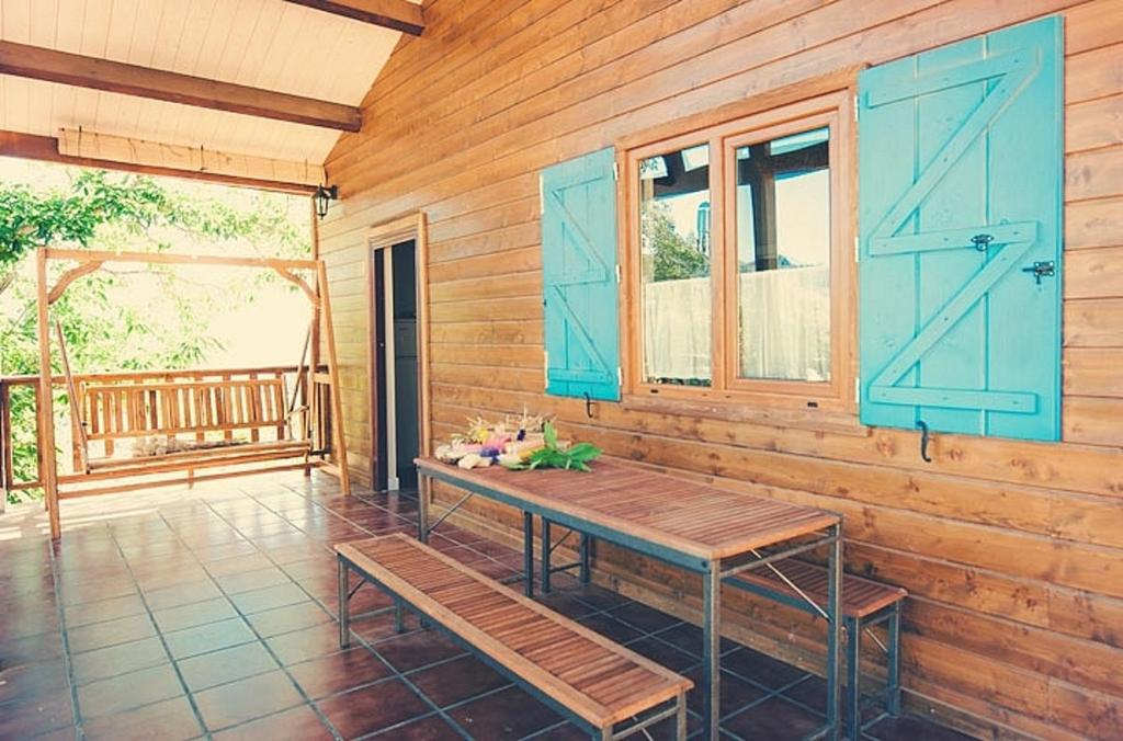 una veranda con porte blu e una parete in legno di 2 bedrooms house with shared pool furnished garden and wifi at Canamero a Cañamero