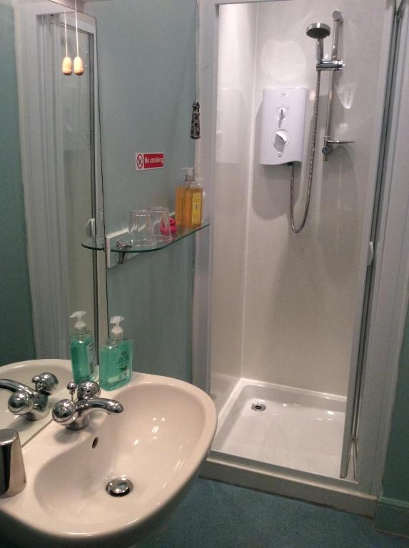 y baño con lavabo y ducha. en Lagganbeg Guest House, en Oban