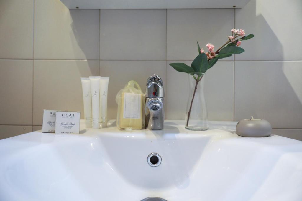 umywalkę w łazience z wazonem kwiatów w obiekcie Welc-ōm Santa Giustina apartment w Padwie