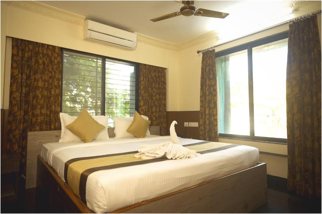 a bedroom with a bed with a towel on it at Apples Balaji Inn in Siliguri