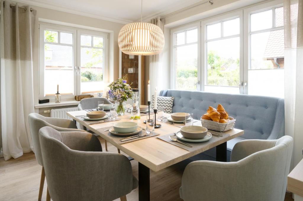 einen Esstisch mit Stühlen und eine blaue Couch in der Unterkunft Ferienhaus Meerweh Sylt in Westerland