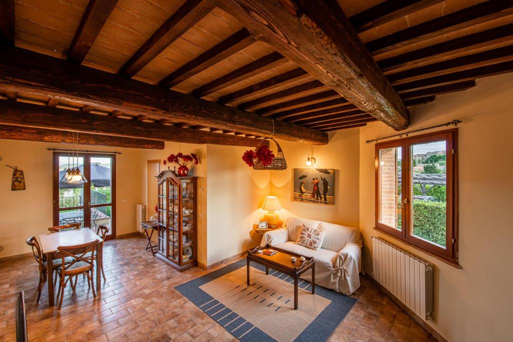 uma sala de estar com um sofá e uma mesa em Le Sorelle, Minnie's Cottage em Montalcino