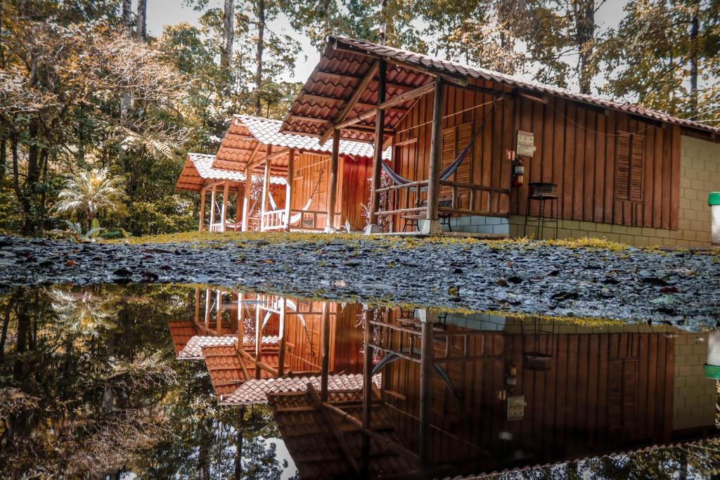 a house in the forest with its reflection in the water at Recreo Verde Hot Springs & Spa in Marsella