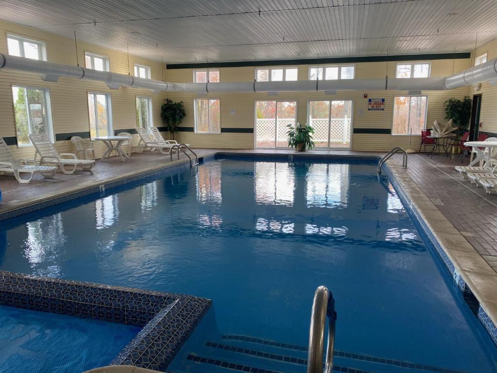 a large swimming pool with blue water in a building at Hometown Inn Indian River in Indian River