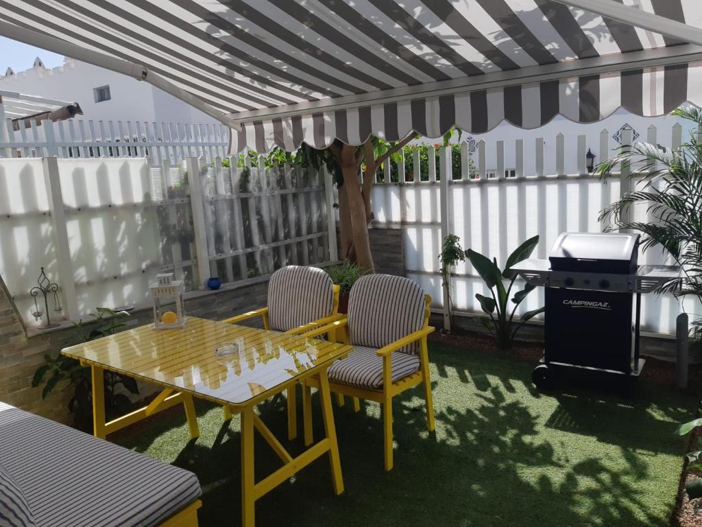 un patio con mesa, sillas y parrilla en Pool View Yard Bungalow, en Playa del Inglés