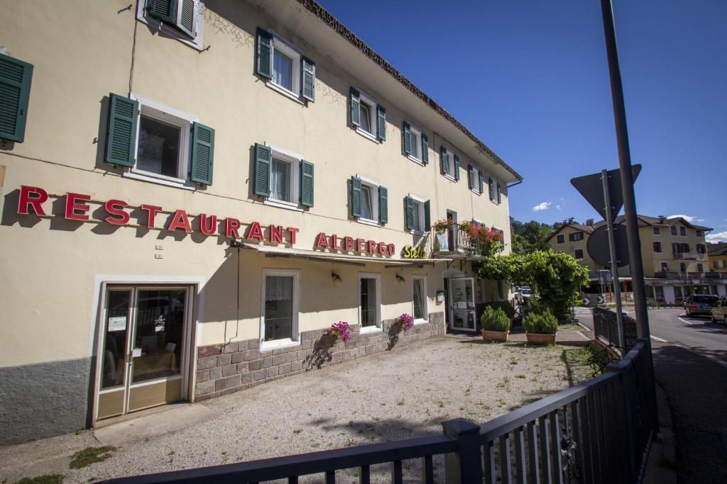 ein Gebäude mit einem Schild an der Seite in der Unterkunft Albergo Stella in Cavalese