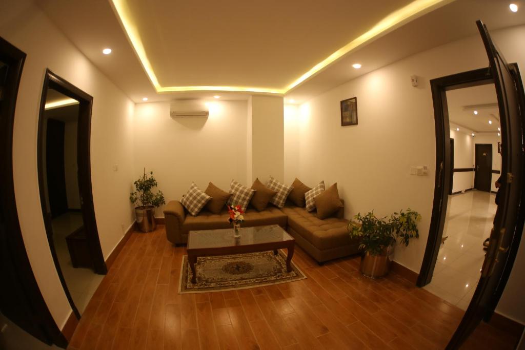 a living room with a couch and a table at Grand Mongolia Hotel in Rawalpindi