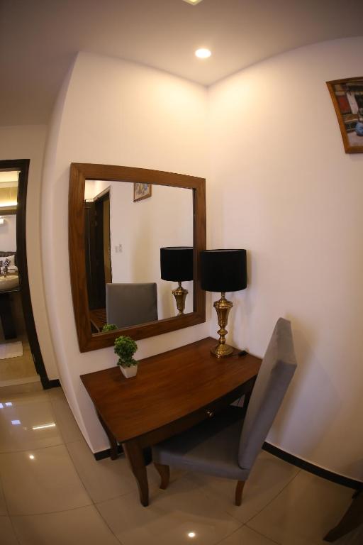 a room with a desk with a mirror and a chair at Grand Mongolia Hotel in Rawalpindi