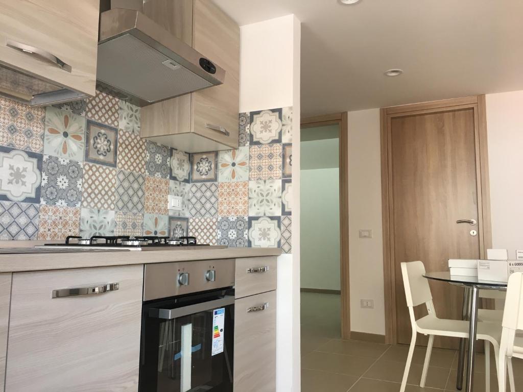 a kitchen with a stove top oven next to a table at VILLA MOGUNTIA in Ficarazzi