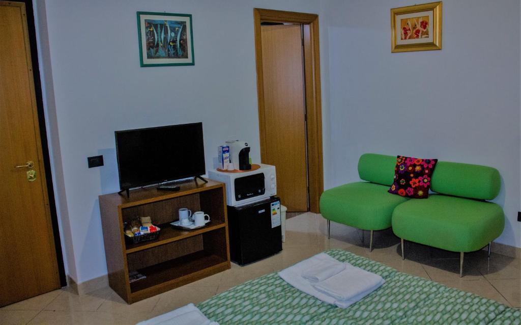 un soggiorno con divano verde e TV di La Casa di Dadà ad Avezzano