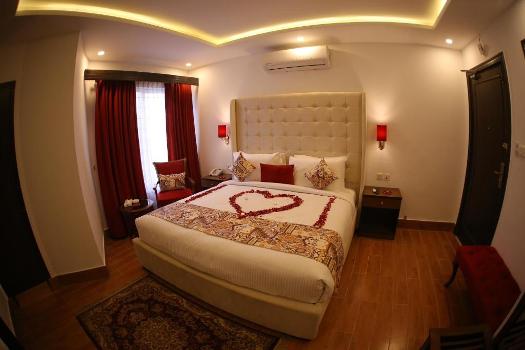a bedroom with a large bed in a room at Grand Mongolia Hotel in Rawalpindi
